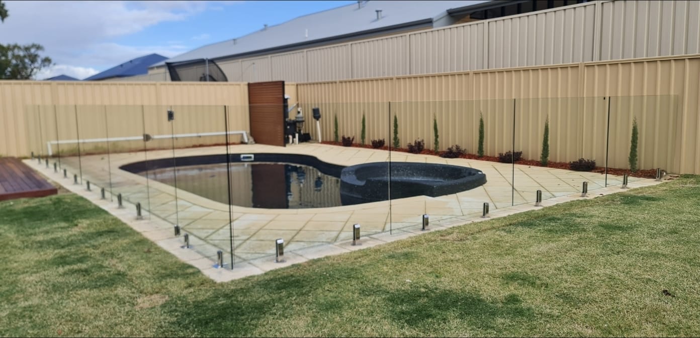 Frameless glass pool fencing installed around a backyard pool in Perth by Perth Glass Repair